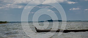 Three seagulls at a lake - on the water, sitting in a boat, and standing on the boat