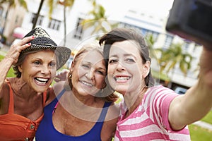 Three Senior Female Friends Taking Selfie In Park