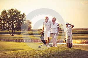 Three senior golfers. Focus is on man and woman