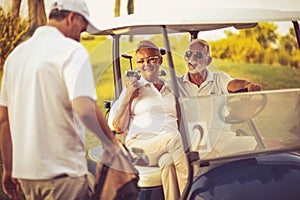 Three senior golfers talking.