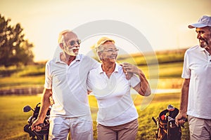 Three senior golfers walking and talking