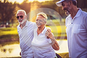 Three senior golfers walking and talking