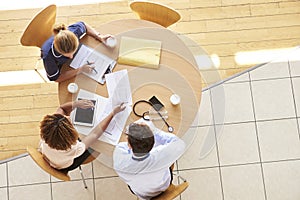 Three senior healthcare workers in a meeting, overhead view