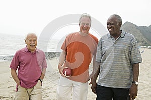 Three senior men walking on beach