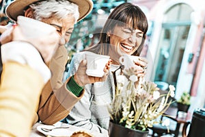 Three senior women enjoying breakfast drinking coffee at bar cafeteria