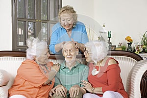 Three Senior Women Lavishing Affection on a Single Man