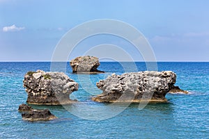 Three separate rocks offshore in sea