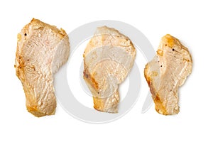 Three separated slices of grilled chicken breast isolated on white. Top view
