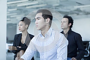 Three serious business people sitting in a business meeting