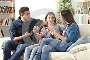 Three serious friends talking sitting on a couch at home photo