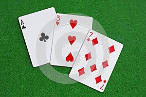 Three, Seven, Ace - playing cards combination on green baize
