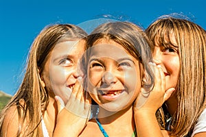 Three seven year old girls playing and whispering