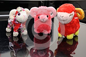 Three sheep stuffed toys arranged aligned in a row