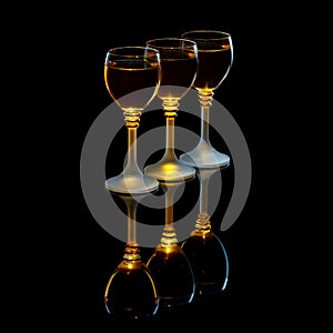 Three shot glasses with alcohol on a black background
