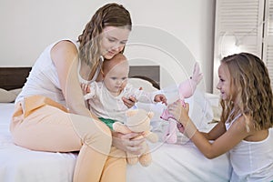 Three sisters play children in the morning in the bedroom