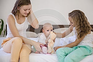 Three sisters play children in the morning in the bedroom