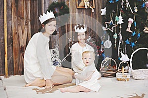 Three sisters posing in front of Christmas tree