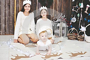 Three sisters posing in front of Christmas tree