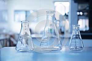 Three size of glass flasks in blue education chemistry science laboratory background