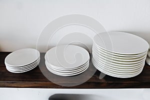 Three size white ceramic plate on the wood shelf