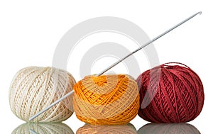 Three skeins of cotton yarn and crochet hook, isolated on white