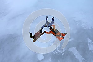 Three skydivers in the winter sky.