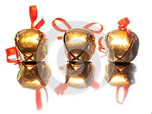 Three sleigh bells with red ribbon bows