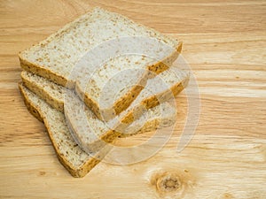 Three slice whole wheat bread on wooden table