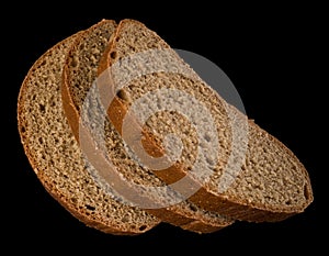 Three slices of dark bread on a black background isolated