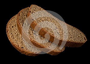 Three slices of dark bread on a black background isolated