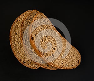 three slices of dark bread, on a black background in isolation