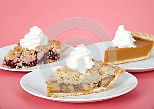 Three slices of pie on plates pink background