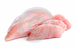 Three slices of uncooked boned chicken breast next to whole chicken breast isolated on white