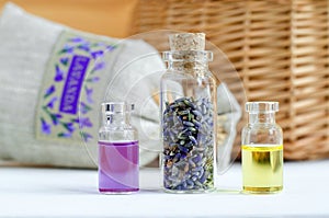 Three small bottles with dry lavender buds, essential oil and natural perfume. Aromatherapy and spa ingredients.