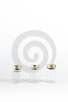 Three small empty glass vials on a white background. Medicine bottles. Copy space. vertical