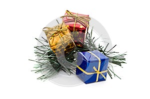 Three small gift boxes on pine branch