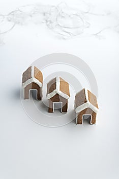 Three small gingerbread houses on white background. Christmas baked goods