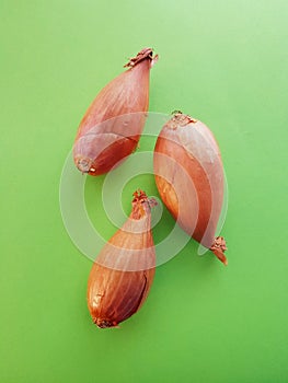 Three small onions over green table. Closeup of three onions.