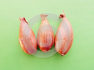 Three small onions over green table. Closeup of three onions.