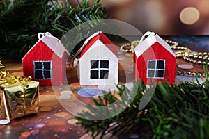 Three small wooden houses on a New Year\'s background. Christmas tree pendants made of wood