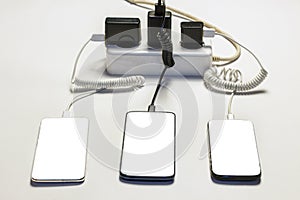 Three smartphones are charged from the mains