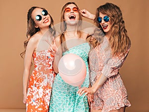 Three smiling beautiful women in summer hipster dresses