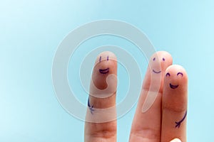 Three smiling fingers that are very happy to be friends. Friendship teamwork concept on blue background with copy space