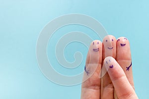 Three smiling fingers that are very happy to be friends. Friendship teamwork concept on blue background with copy space