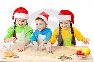 Three smiling kids with Christmas cooking