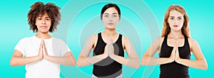 Three smiling multiracial women with different types of skin: caucasian, african american and asian girls in namaste pose isolated photo