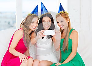 Three smiling women in hats having fun with camera