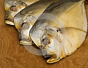Three smoked vomer fish, lie on a wooden board