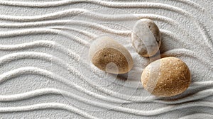 Three smooth stones on a textured sand surface with rippled patterns
