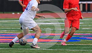 Three soccer players working to get controll of the ball